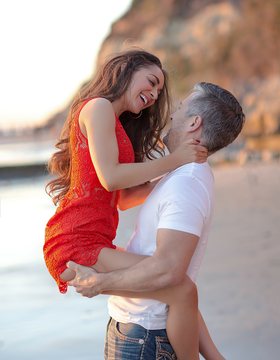Couple laughing on the beach at sunset