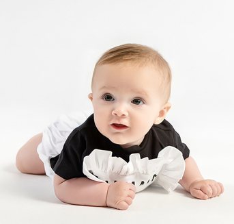 Baby lying on a white studio backdrop
