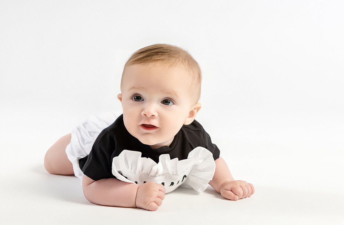 Baby lying on a white studio backdrop